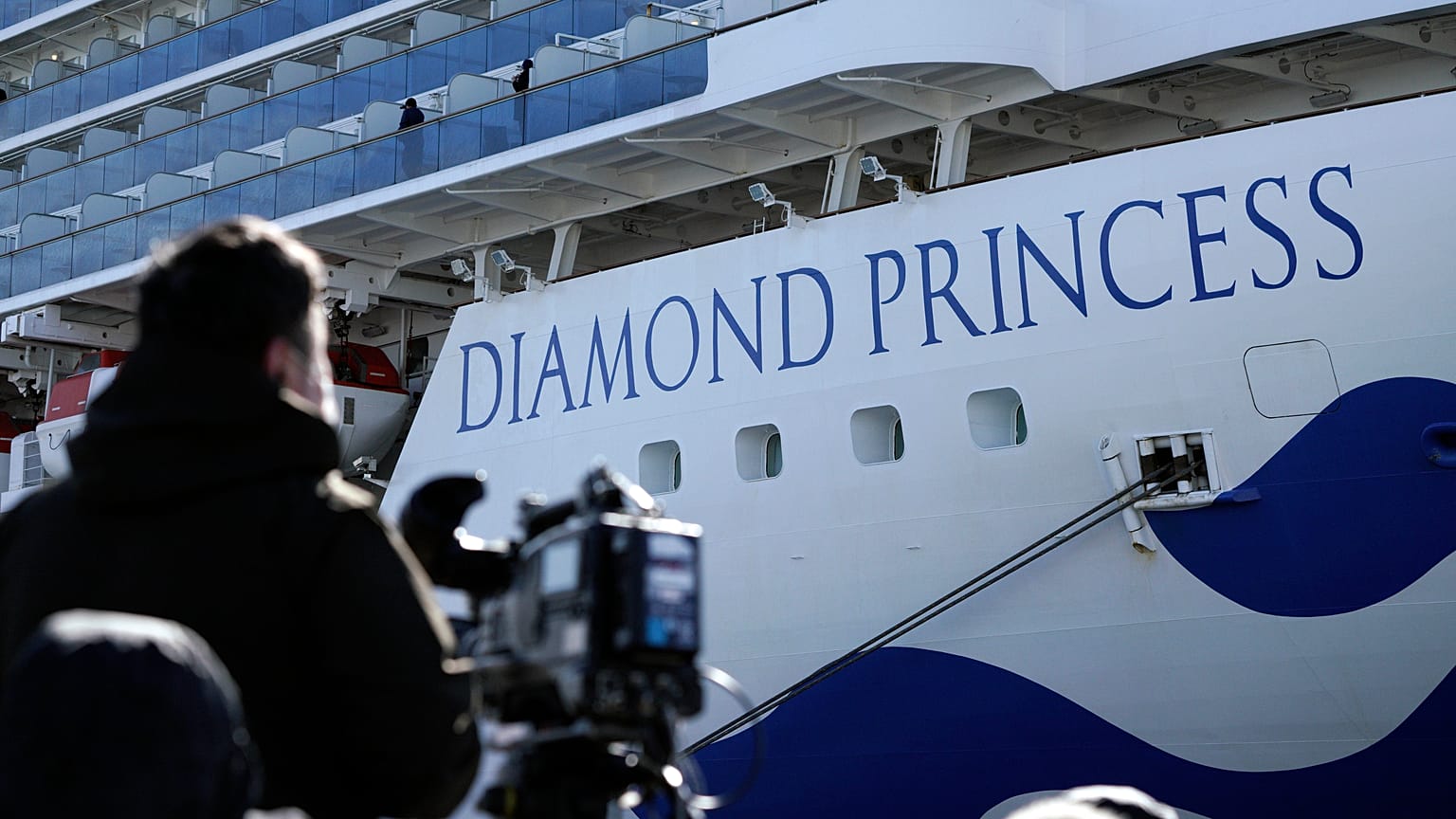 Un periodista con su cámara junto al crucero Diamond Princess, Yokohama, Japón