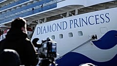 Un periodista con su cámara junto al crucero Diamond Princess, Yokohama, Japón