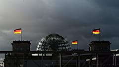 German national flags catch the sun on top of the German parliament building, the Reichstag building in Berlin, Germany, Friday, Nov. 29, 2019. 