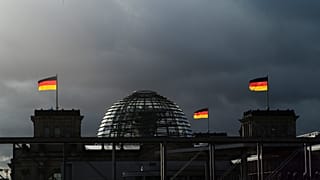 German national flags catch the sun on top of the German parliament building, the Reichstag building in Berlin, Germany, Friday, Nov. 29, 2019.
