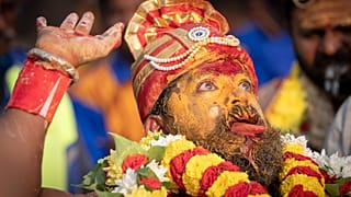 A Tamil Hindu priest has antiseptic powder on his face in a procession during the Thaipusam festival