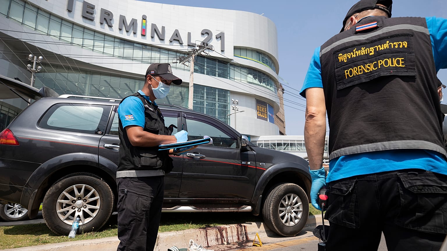 Forensic officers inspect a shooting scene outside the Terminal 21 Korat mall in Nakhon Ratchasima, Thailand, Sunday, Feb. 9, 2020.