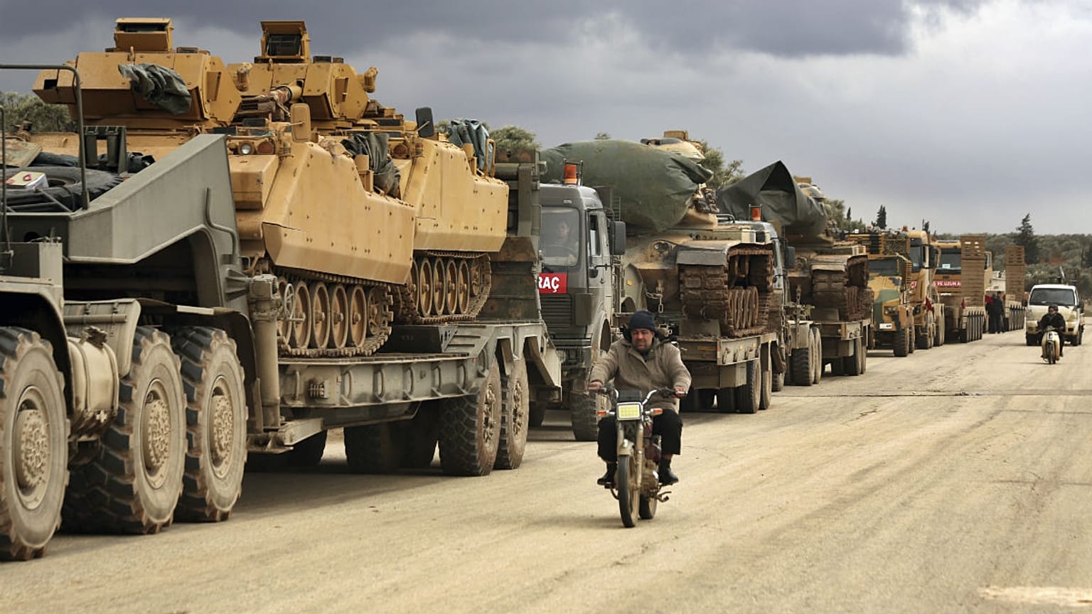 Turkish military convoy drives through the village of Binnish, in Idlib province, Syria, Saturday, Feb. 8, 2020.