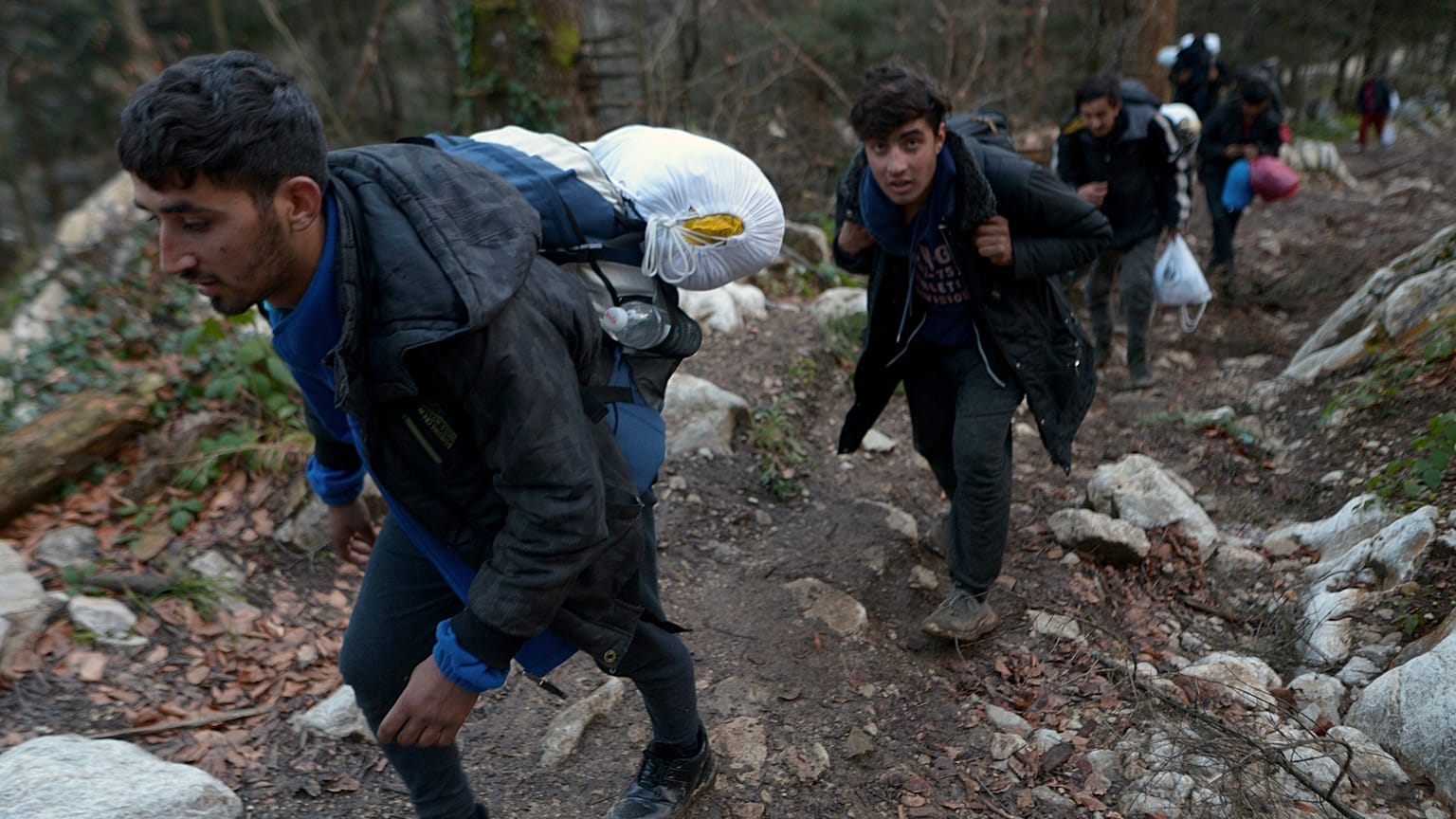 Migrants climb through woods near Bosnia-Croatia border near Bihac, northwestern Bosnia, Sunday, Dec. 8, 2019.