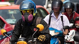 Tayland'da hava kirliliğinden korunmak için maske takan sürücüler
