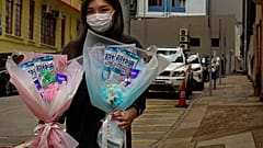 Flower shop owner Iris Leung wears her protective face mask as she delivers flowers with masks to customers on Valentine's Day in Hong Kong, Friday, Feb. 14, 2020.