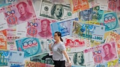 إمرأة تسيرة أمام مصرف للعملات في مركز الأعمال في هونغ كونغ بالصين. 06/08/2019