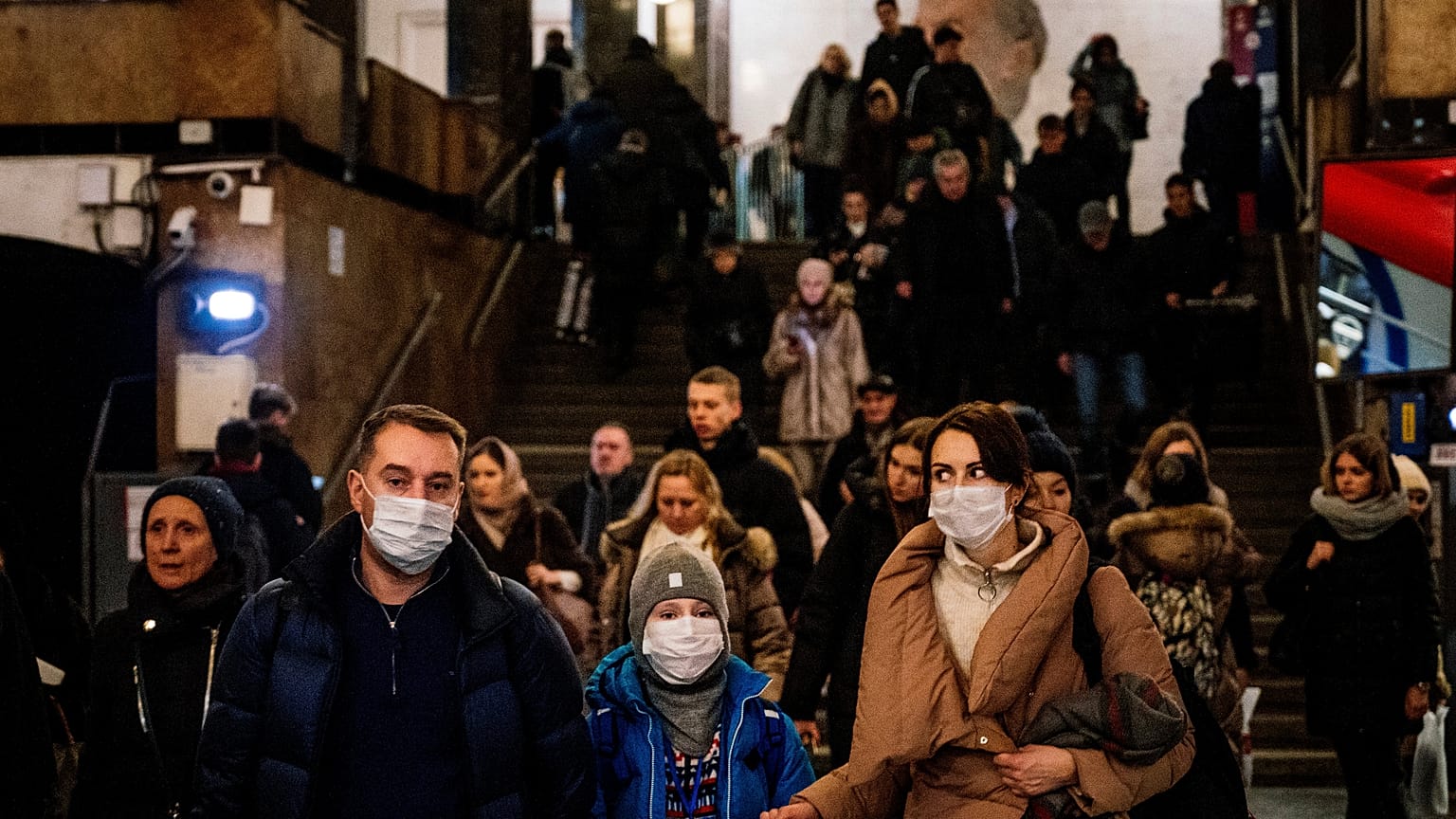 A family wearing a face mask walk in Biblioteka Imeni Lenina metro station in Moscow on February 7, 2020.