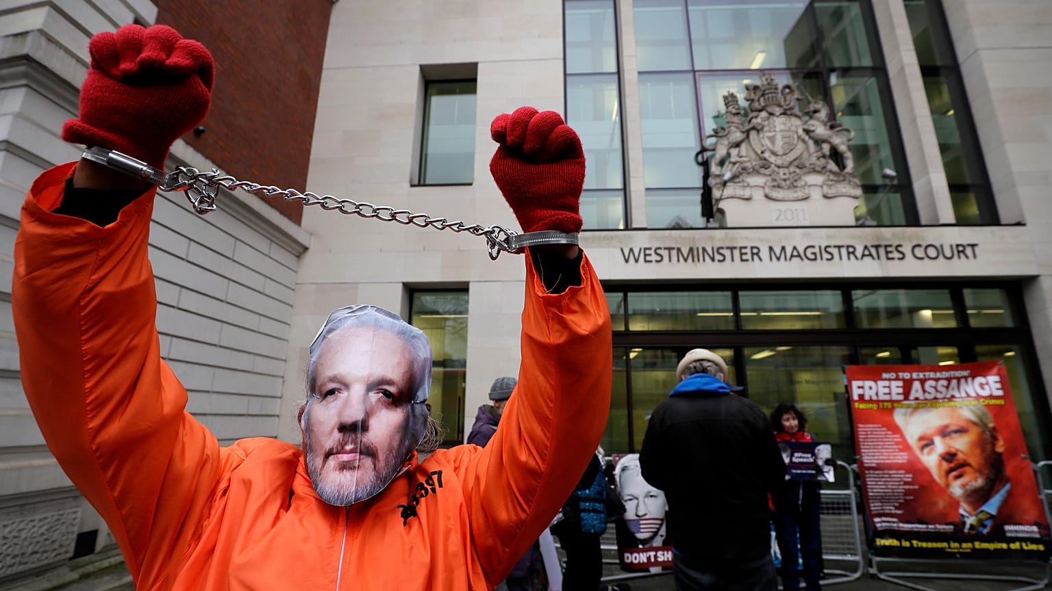 FILE PHOTO: A demonstrator supporting Julian Assange wears a mask and chains outside Westminster Magistrates Court in London, Thursday, Jan. 23, 2020. 