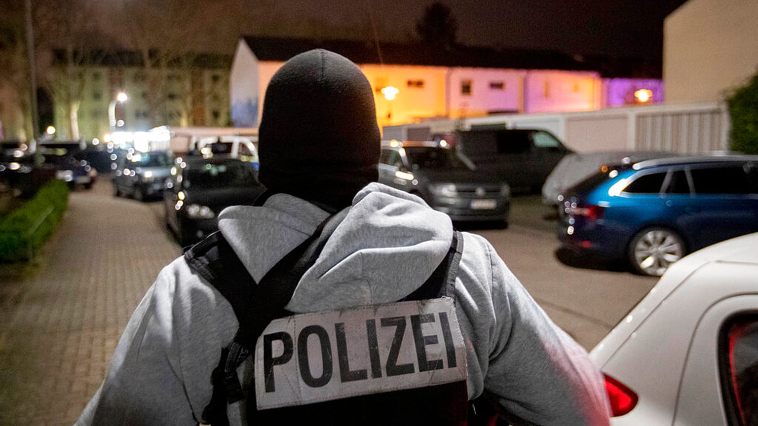A police officer guards the road in front of a house that is searched through by police in Hanau, Germany Thursday, Feb. 20, 2020. (AP Photo/Michael Probst)