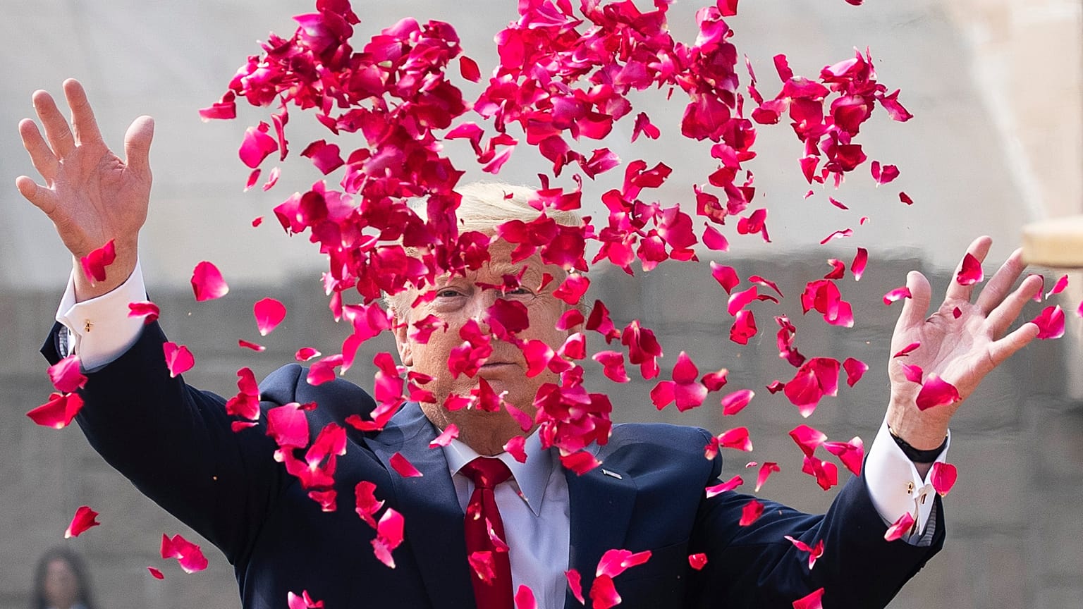 President Donald Trump throws rose petals during a ceremony at the Raj Ghat Mahatma Gandhi Memorial, in New Delhi, India.
