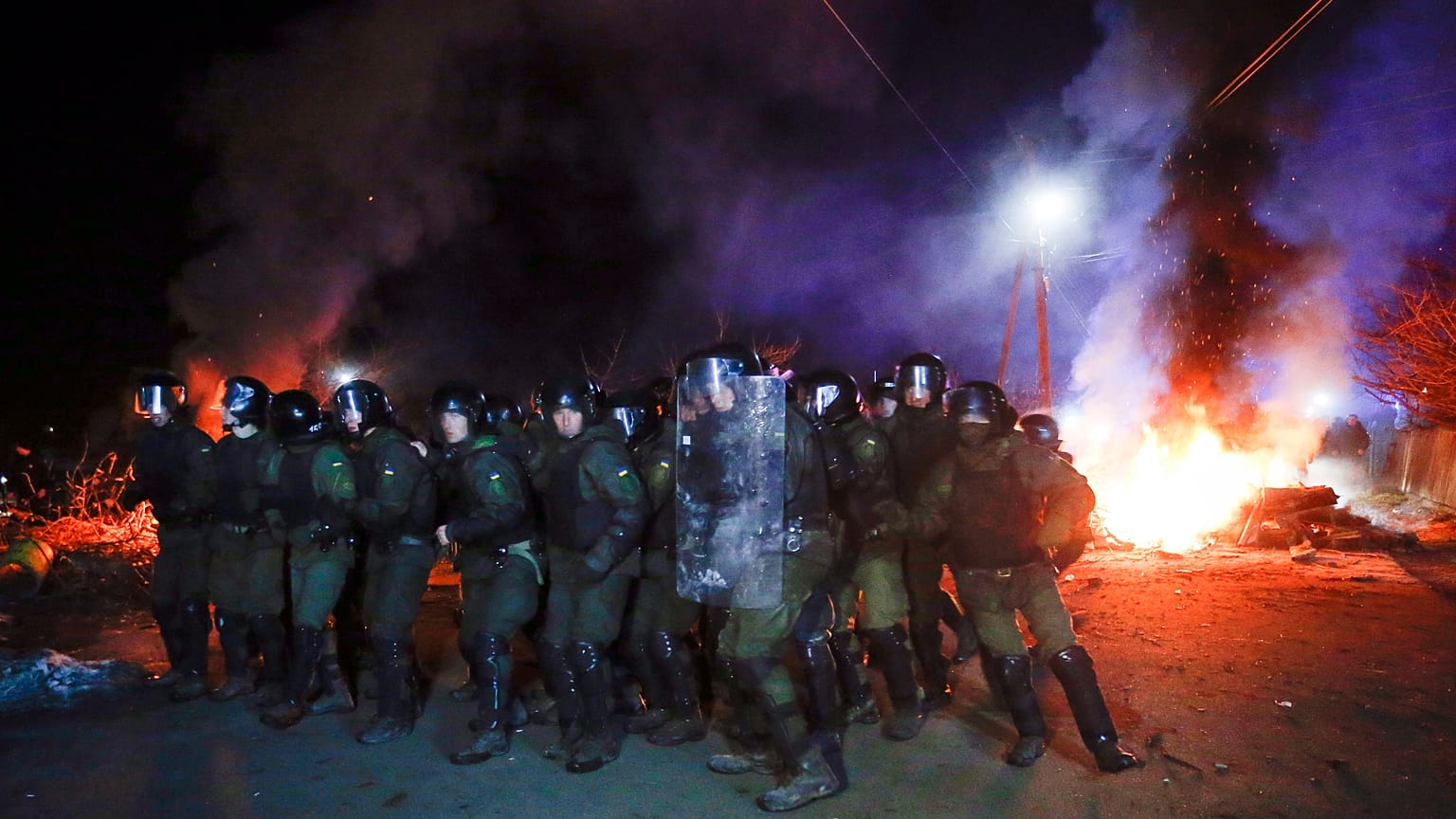 La policía antidisturbios ucraniana se prepara para hacer retroceder a los manifestantes en las afueras de Novi Sarzhany, Ucrania
