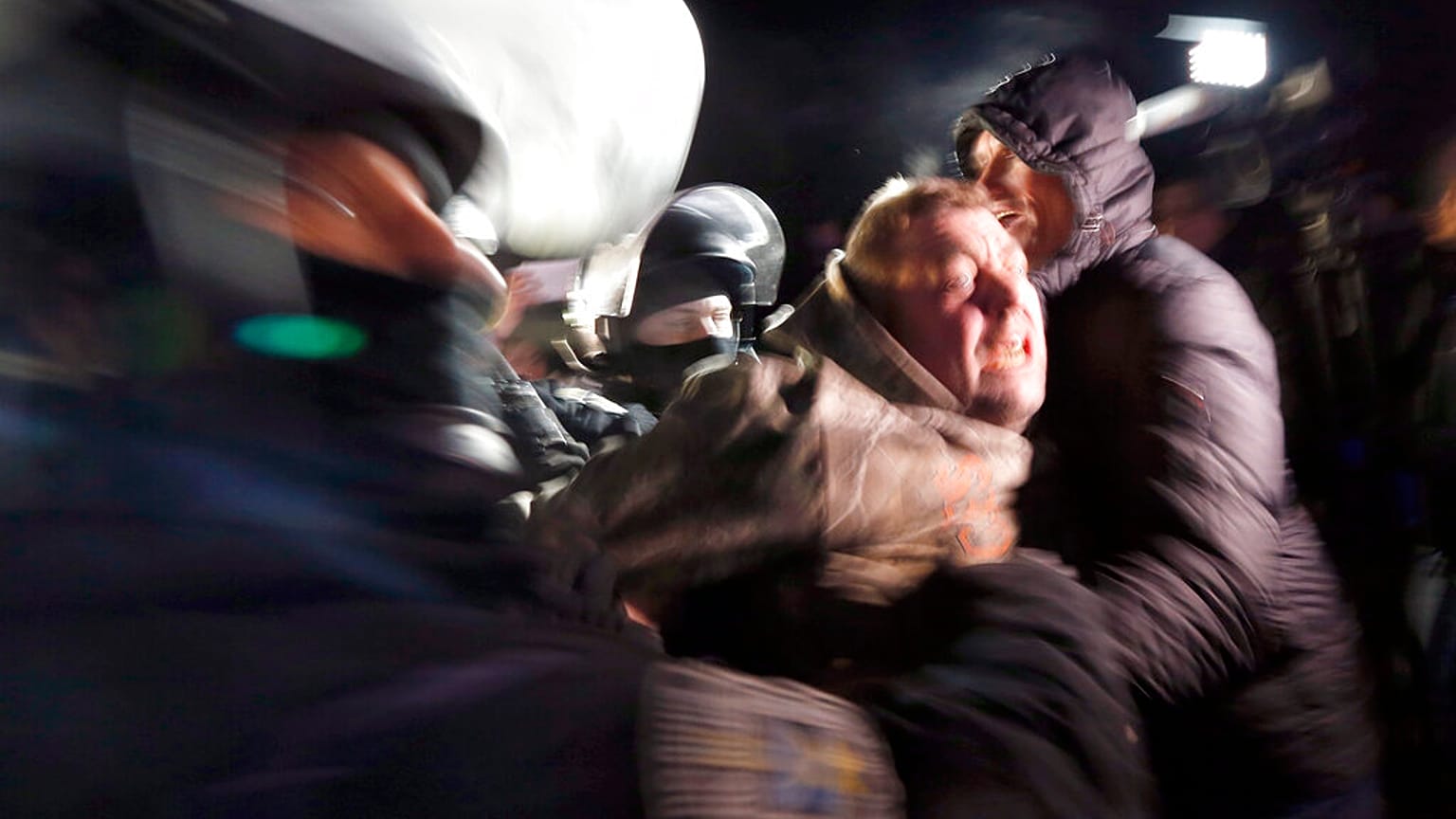 Ukrainian riot police detain a protester, who planned to stop buses carrying passengers evacuated from the Chinese city of Wuhan, outside Novi Sarzhany, Ukraine.