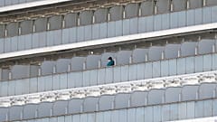 A passenger stands on the balcony of the quarantined Diamond Princess cruise ship at a port in Yokohama, near Tokyo, Friday, Feb. 21, 2020  