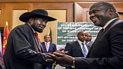 رئيس جمهورية جنوب السودان سيلفا كيير (على الشمال) يصافح زعيم المعارضة ريك مشار خلال محادثات السلام في أديس أبابا. 