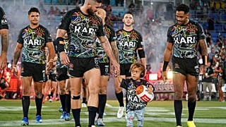 Quaden Bayles, (9), lidera al Indigenous All Stars en el campo con el capitán Joel Thompson antes del partido NRL Indigenous All-Stars vs Maori Kiwis en el CBus Super Stadium