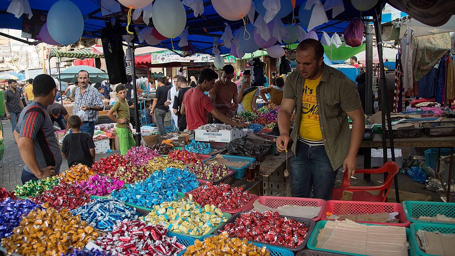Palestinians buy sweets for upcoming Eid al-Adha holiday at the central Gaza main market in Gaza City, in the northern Gaza Strip