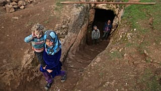 Gyerekek jönnek ki egy menekült család föld alatti búvóhelyéről