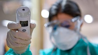Olaszországból hazatért utasok testhőmérsékletét mérik a milánói járat érkezése után a debreceni repülőtéren 2020. február 25-én