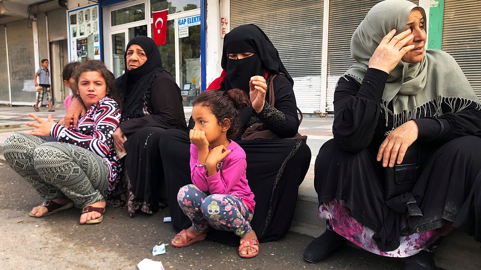 Syrian refugees living in Akcakale, southeastern Turkey, wait for bread distribution by the local municipality