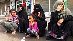 Syrian refugees living in Akcakale, southeastern Turkey, wait for bread distribution by the local municipality