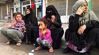 Syrian refugees living in Akcakale, southeastern Turkey, wait for bread distribution by the local municipality