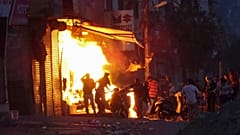 Una tienda arde incendiada por una multitud la incendia durante los violentos disturbios en Nueva Delhi, India.