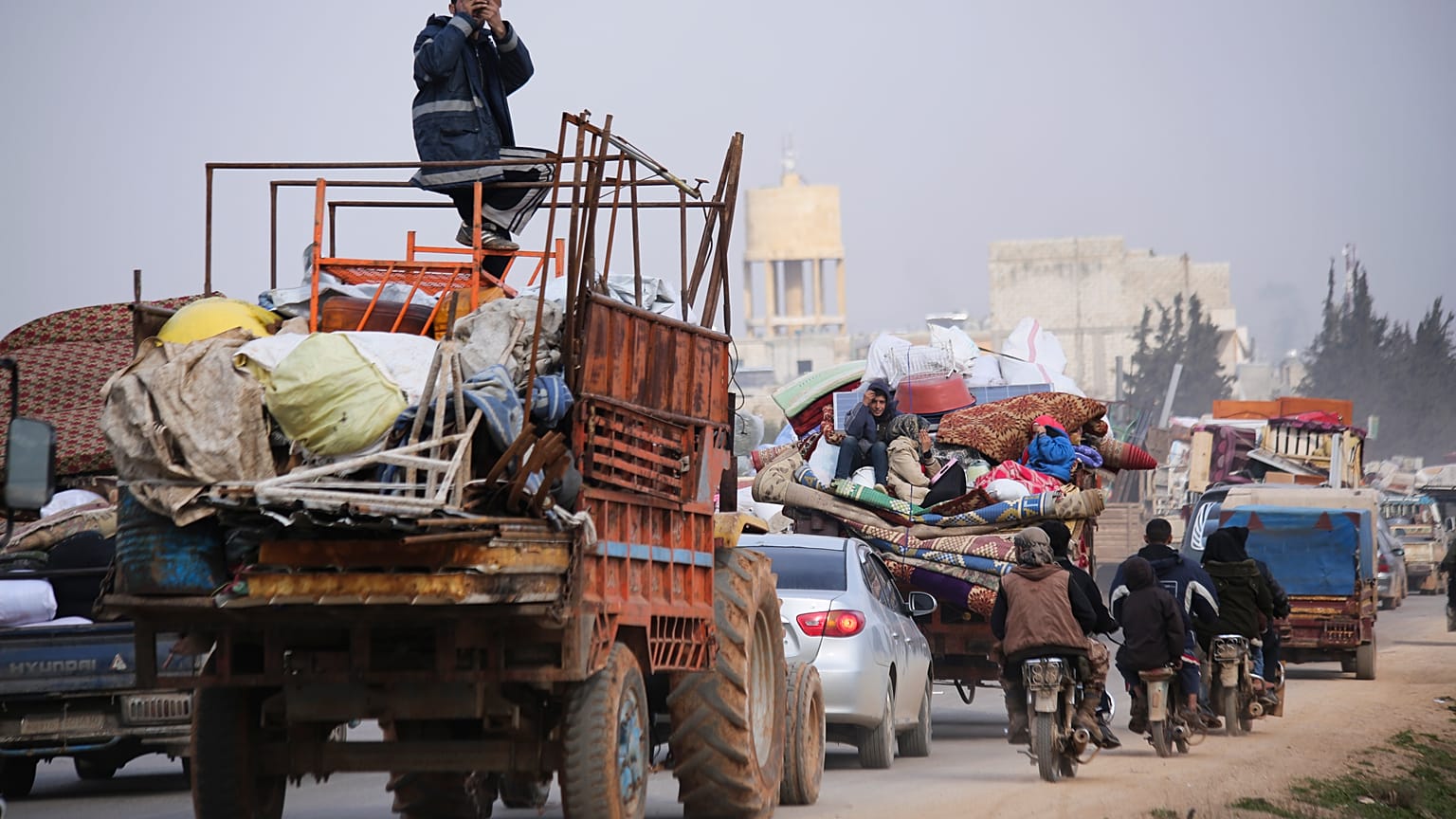 Syrian refugees head northwest through the town of Hazano in Idlib province as the flee renewed fighting Monday, Jan. 27, 2020. 