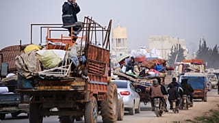 Syrian refugees head northwest through the town of Hazano in Idlib province as the flee renewed fighting Monday, Jan. 27, 2020. 