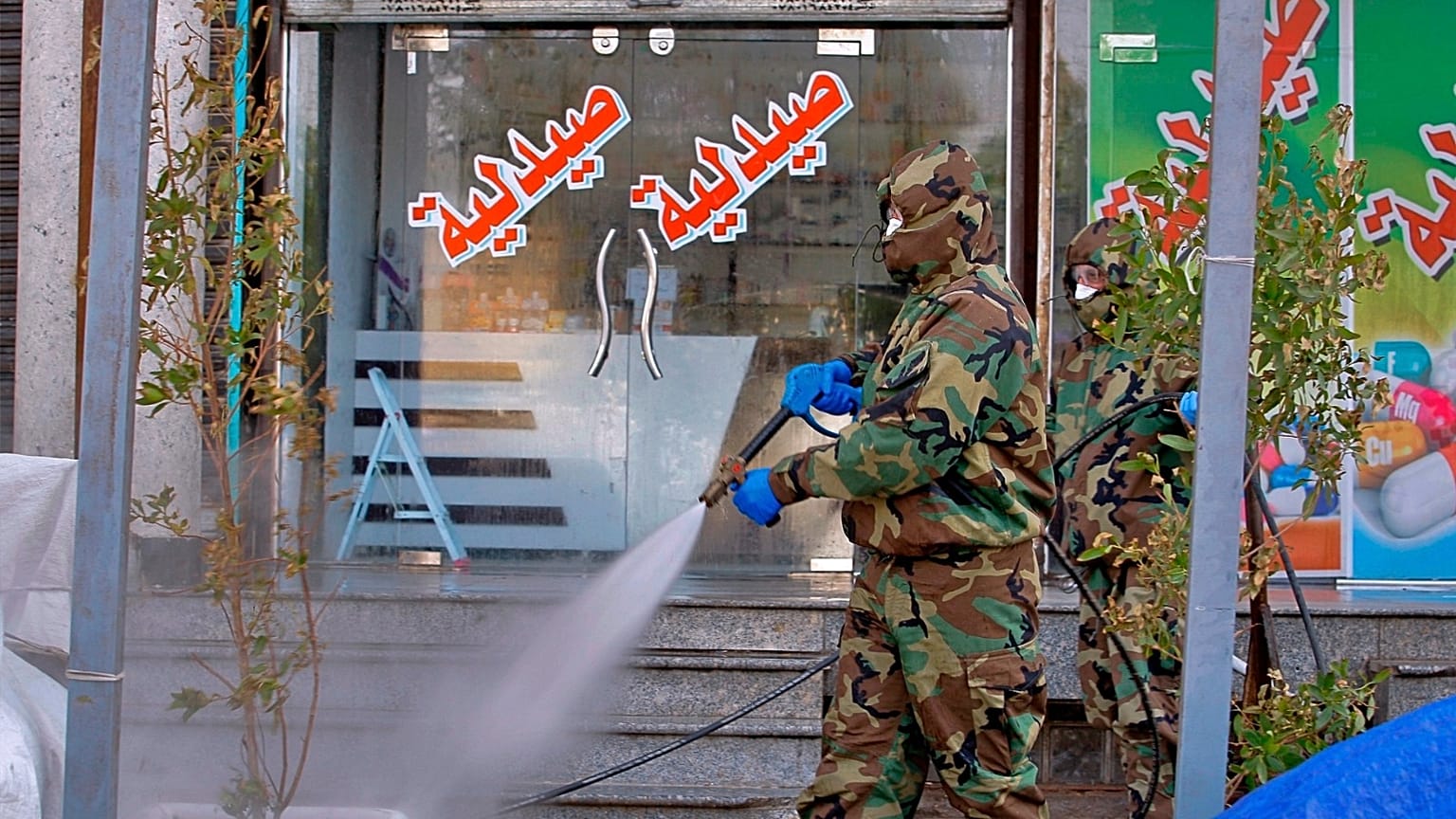 عامل دفاع مدني يستعمل رذاذا مطهرا كإجراء وقائي ضد فيروس كورونا في الأسواق التجارية ووسط المدينة في النجف بالعراق