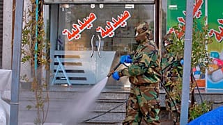 عامل دفاع مدني يستعمل رذاذا مطهرا كإجراء وقائي ضد فيروس كورونا في الأسواق التجارية ووسط المدينة في النجف بالعراق