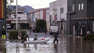Des habitants traversent une rue inondée avec un canot pneumatique pour inspecter les dégâts dans la ville de Fréjus, en France, lundi 2 décembre 2019.