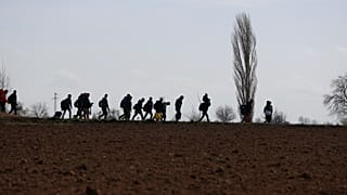 Migrants walk near the Pazarkule border gate in Edirne, at the Turkish-Greek border on Monday, March 2, 2020.