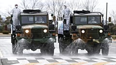 Army trucks spray disinfectant against coronavirus on a street Ulsan, South Korea