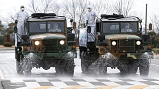 Army trucks spray disinfectant against coronavirus on a street Ulsan, South Korea
