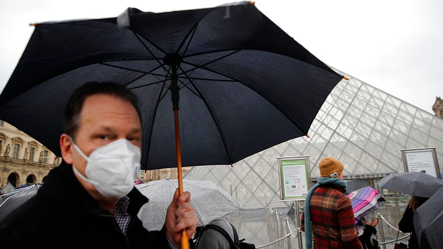 COVID-19 is placing huge demand on masks and gloves, the WHO warned. A tourist wears one outside the Louvre in Paris. 