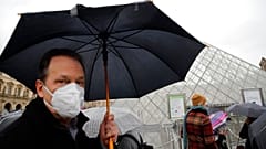 COVID-19 is placing huge demand on masks and gloves, the WHO warned. A tourist wears one outside the Louvre in Paris. 