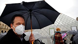 COVID-19 is placing huge demand on masks and gloves, the WHO warned. A tourist wears one outside the Louvre in Paris. 
