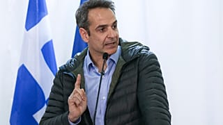 Greek Prime Minister Kyriakos Mitsotakis gestures during a press conference.