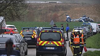 Gendarmes and firefighters gather at the site where a high-speed TGV train locomotive derailed 