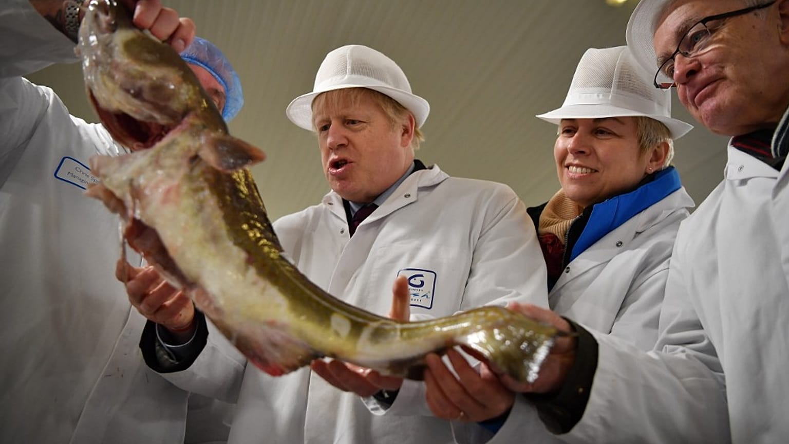 Britain's Prime Minister Boris Johnson poses holding a cod during a general election campagin visit to Grimsby Fish Market in northeast England.