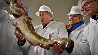 Britain's Prime Minister Boris Johnson poses holding a cod during a general election campagin visit to Grimsby Fish Market in northeast England.