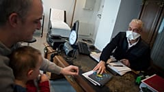 A family doctor in France wears a protective face mask as a preventive measure against the spread of COVID-19