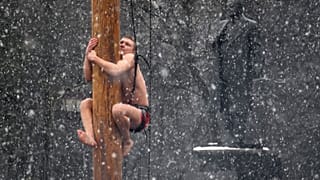 A man climbs on a pole in snowfall to get a prize during celebrations of Maslenitsa, or Pancake Week, in Veliky Novgorod, Russia.