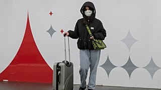 A woman wears a mask as she waits for a train in Paris, Friday, March 6, 2020.
