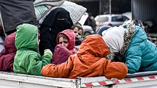 Civilians flee from Idlib toward the north to find safety inside Syria near the border with Turkey, Saturday, Feb. 15, 2020