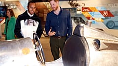 Rennfahrer Hamilton und Prinz Harry betrachten historischen Sportwagen