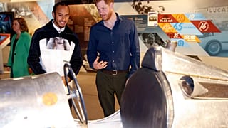 Rennfahrer Hamilton und Prinz Harry betrachten historischen Sportwagen