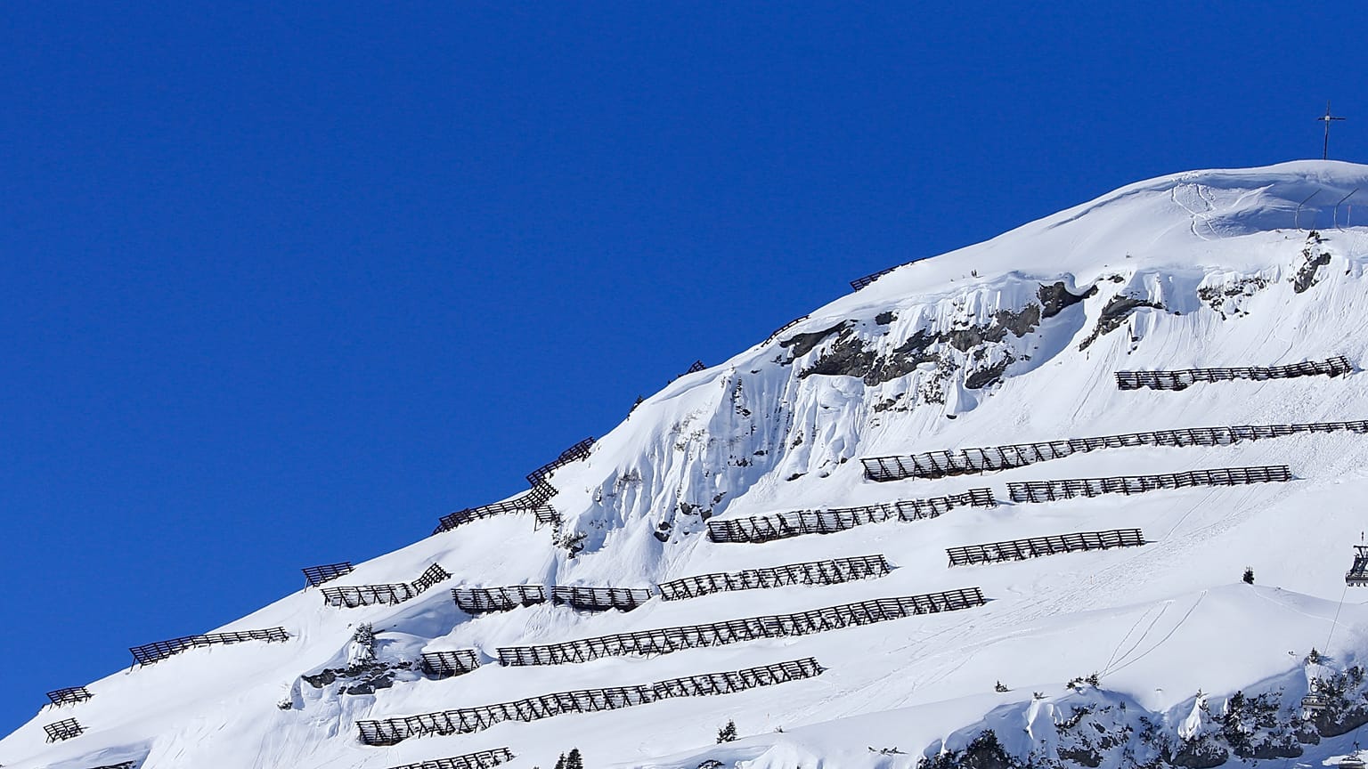 Schneezäune zum Lawinenschutz nahe Lech am Arlberg in Österreich. 