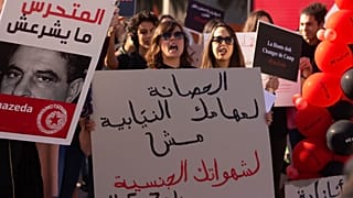 متظاهرة تونسية ترفع لافتة كتب عليها "الحصانة لمهامك النيابية مش لشهواتك الجنسية"